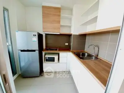 Modern kitchen with sleek appliances and wooden countertops in a stylish apartment.