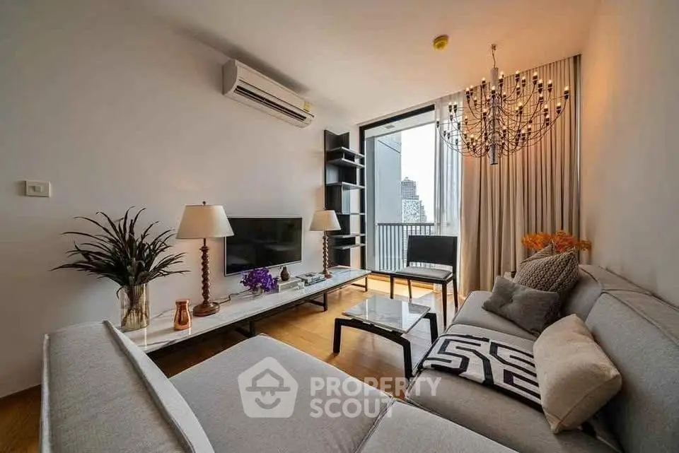 Modern living room with elegant chandelier and city view balcony