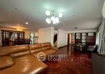 Spacious living room with elegant leather sofa and wooden flooring