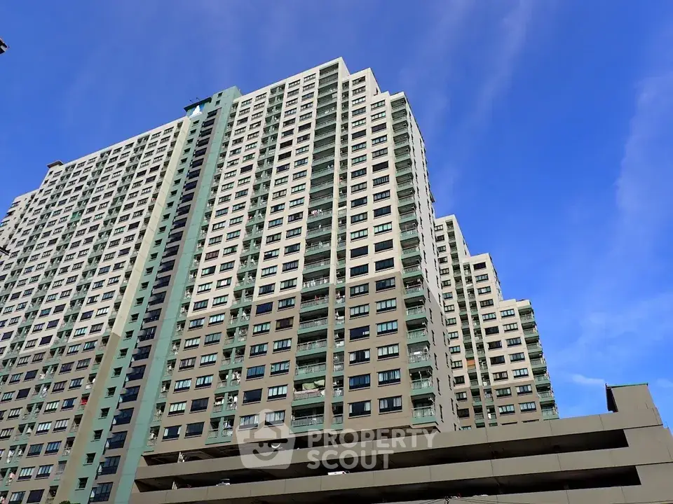 Stunning high-rise residential building against a clear blue sky, showcasing modern urban living.