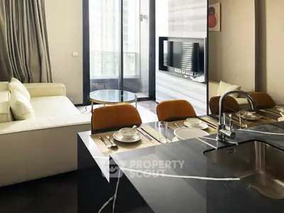 Modern open-plan living room with sleek kitchen and balcony view