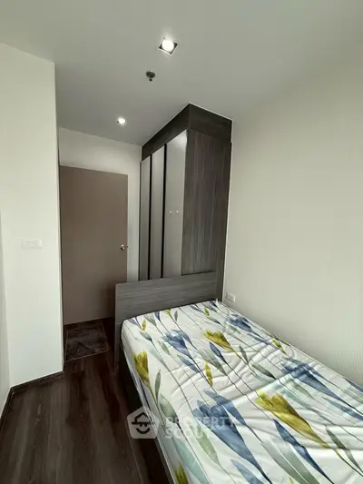 Modern bedroom with sleek wardrobe and floral bedding in minimalist design.