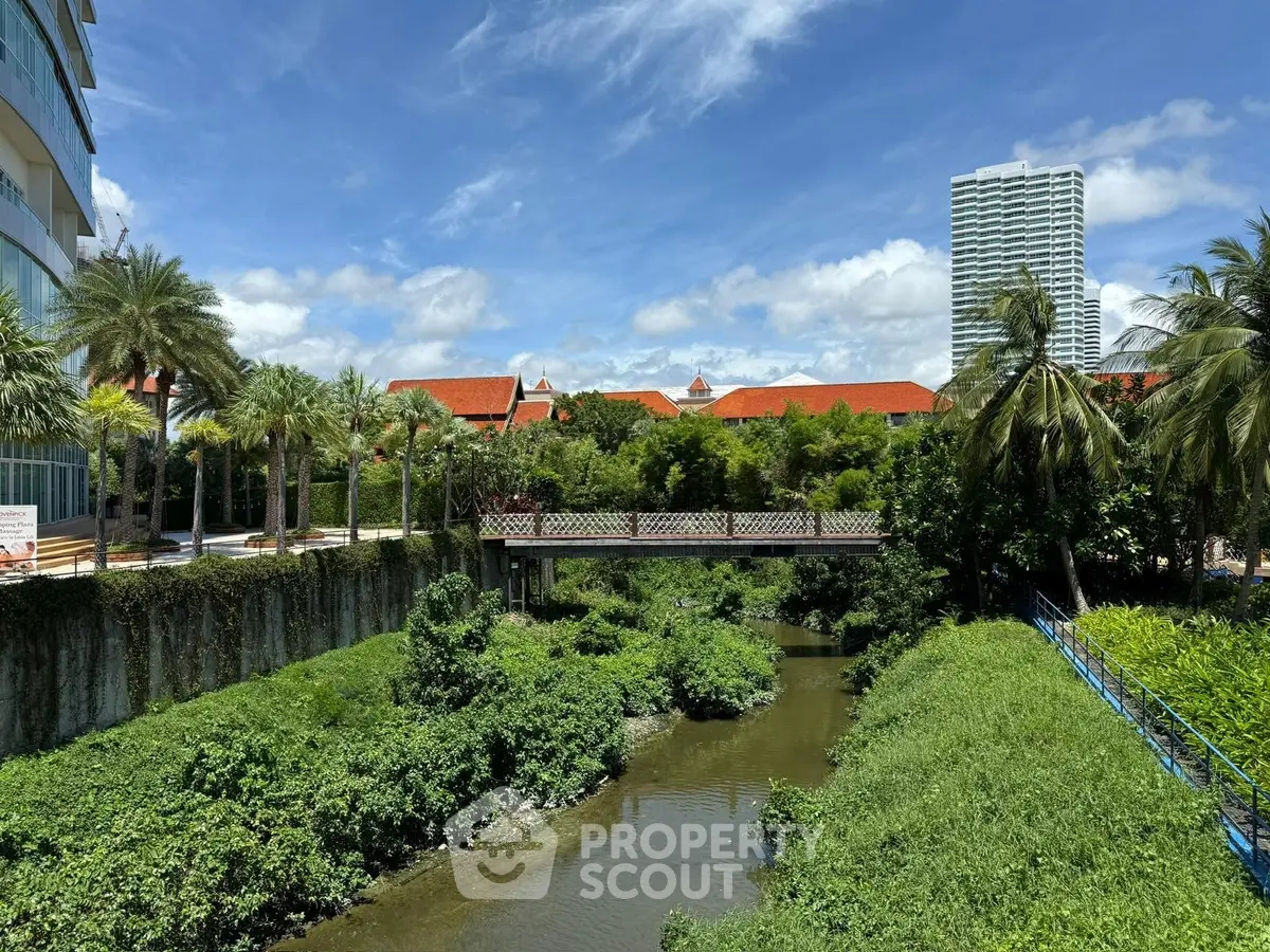 Scenic view of lush greenery and modern buildings with a serene waterway.
