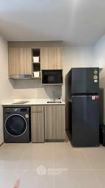 Modern compact kitchen with sleek appliances and wood cabinetry