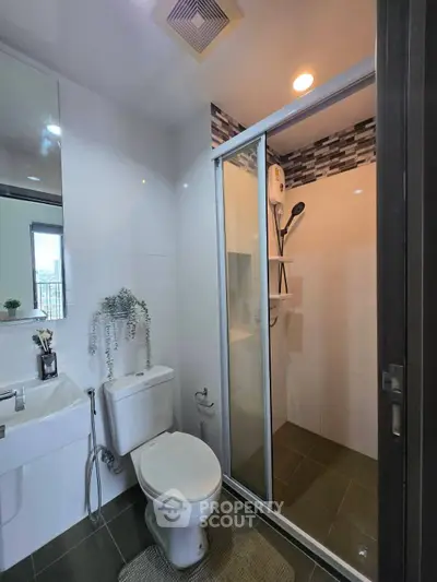 Modern bathroom with glass shower enclosure and sleek fixtures