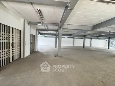 Spacious industrial warehouse interior with high ceilings and open floor plan.
