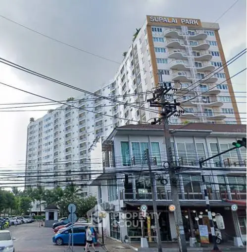 Modern high-rise residential building with balconies in urban setting, showcasing contemporary architecture.