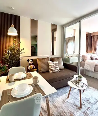 Modern open-plan living room with dining area and cozy bedroom in stylish apartment.