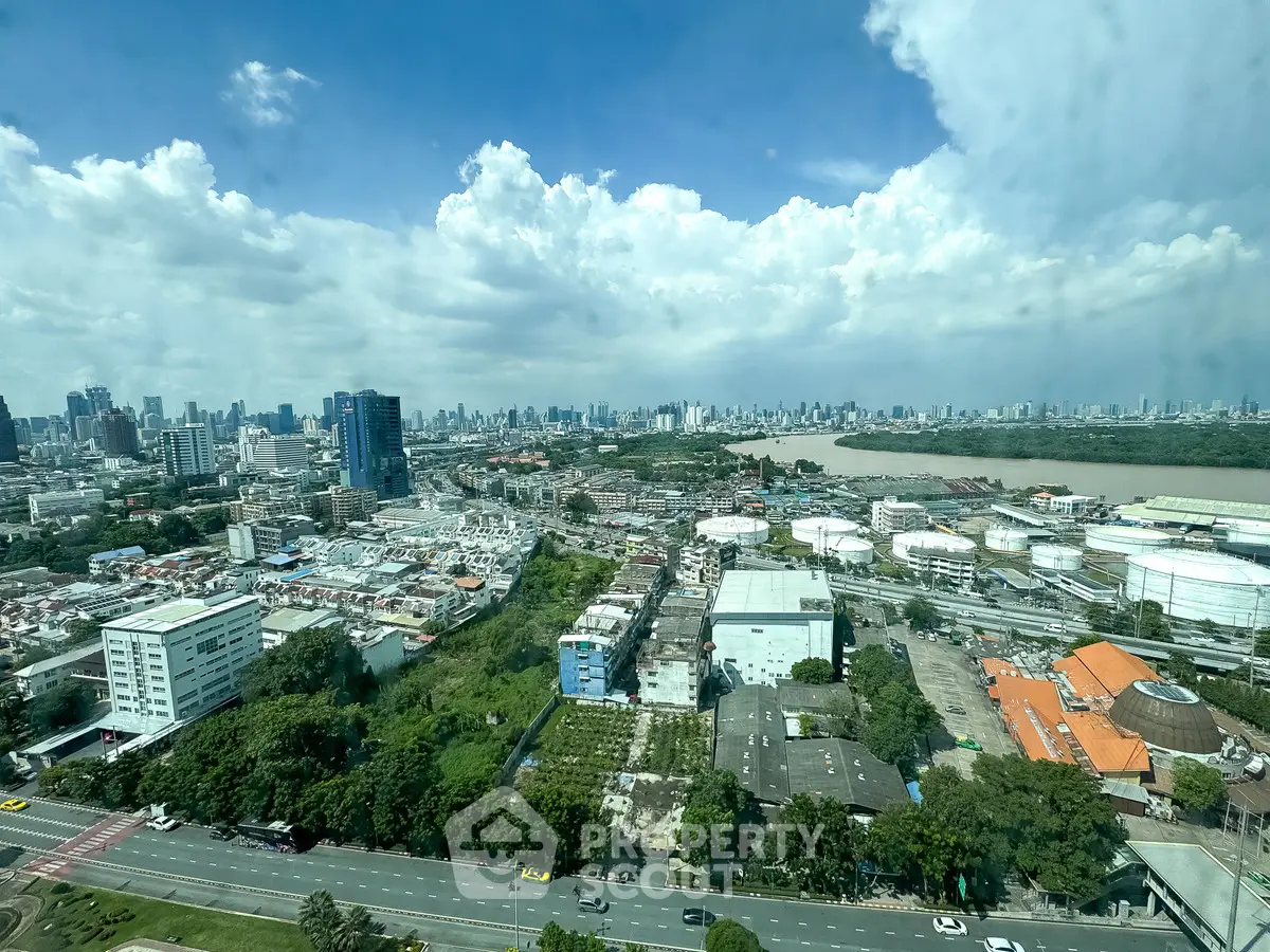 Stunning cityscape view from high-rise building showcasing urban skyline and river under a vibrant blue sky.