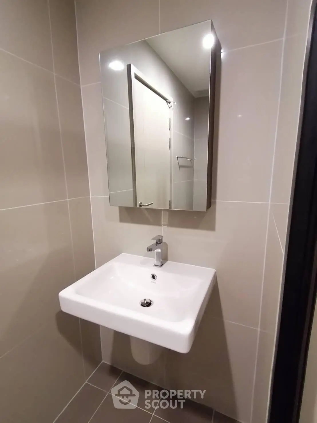 Modern bathroom with sleek sink and mirror in a minimalist design.