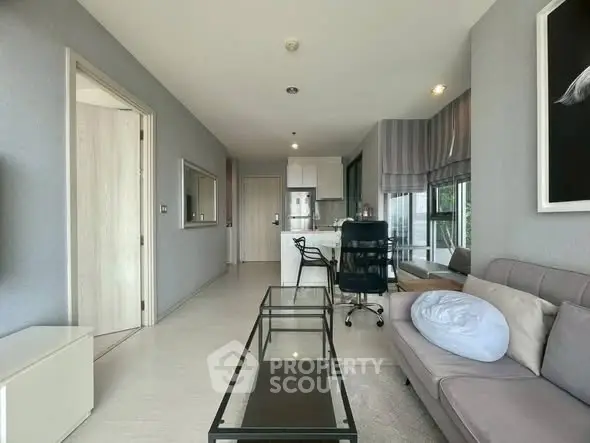 Modern living room with sleek furniture and open kitchen layout in a stylish apartment.