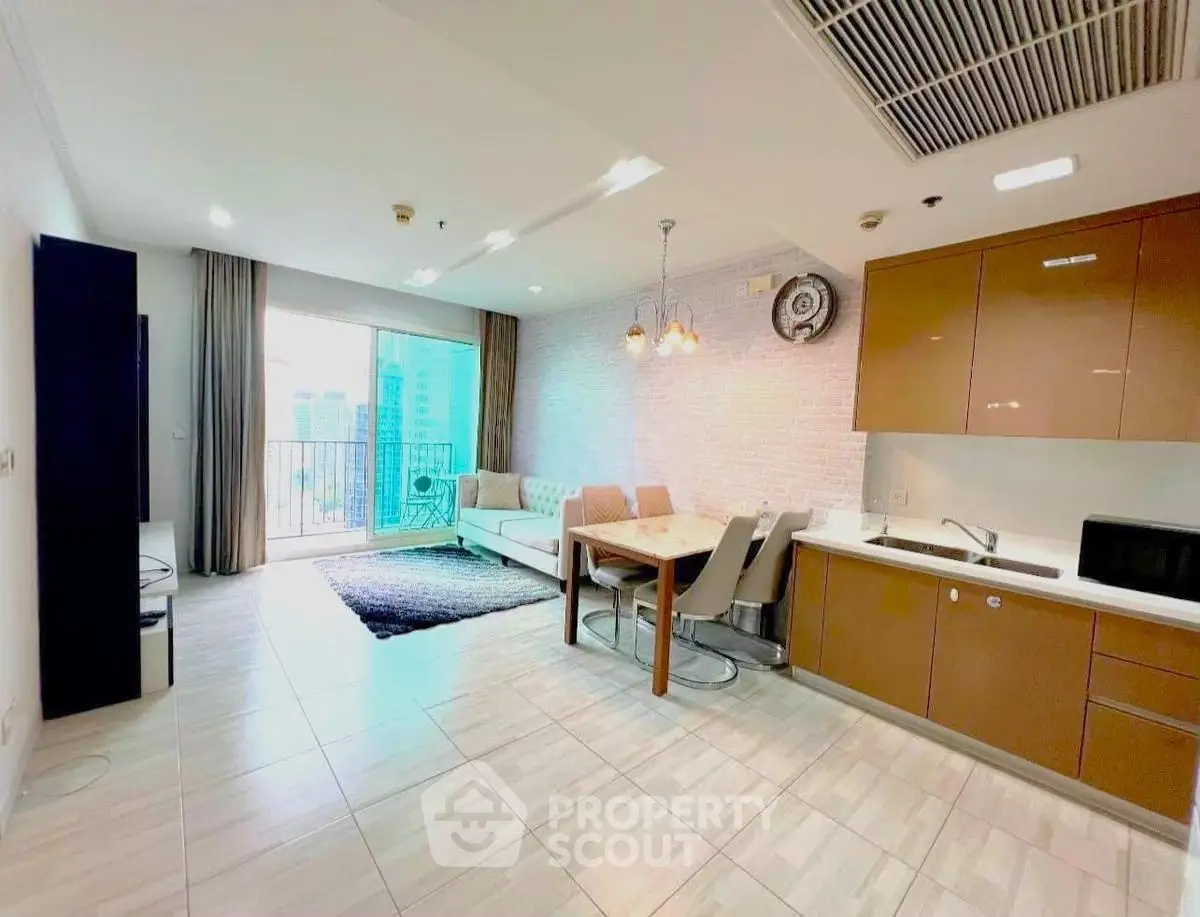 Modern open-layout living room with kitchen, featuring sleek furniture and city view balcony.