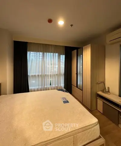 Cozy bedroom with large window and modern furniture in a stylish apartment.