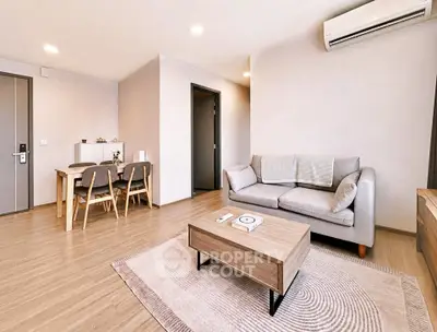 Modern living room with stylish furniture and dining area in open layout apartment.