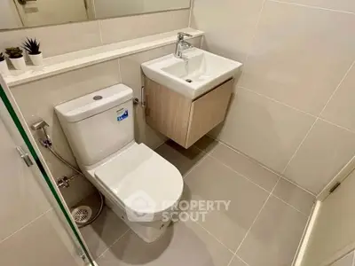 Modern bathroom with sleek fixtures and neutral tiles, perfect for a contemporary home.
