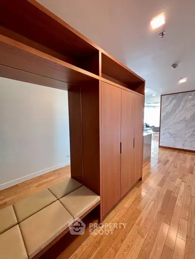 Spacious modern living area with wooden flooring and built-in seating, perfect for stylish urban living.