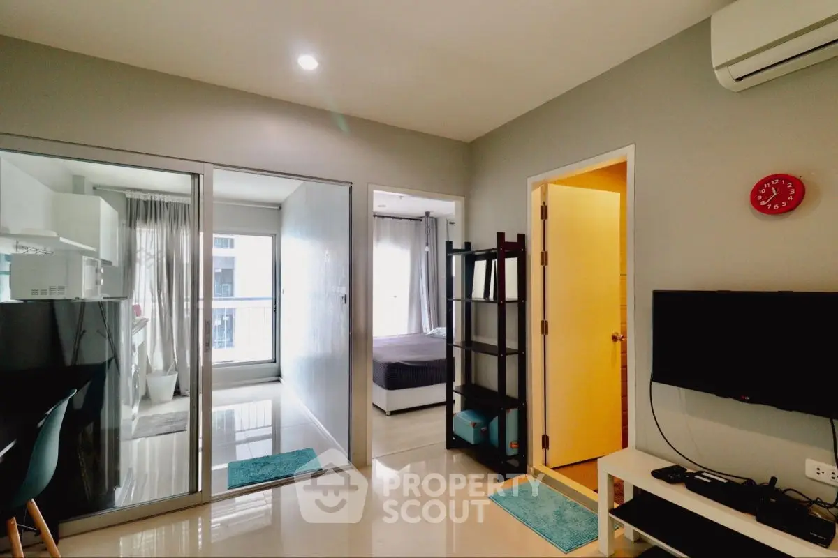 Modern apartment interior with open layout, featuring a cozy living area and bedroom with large windows.