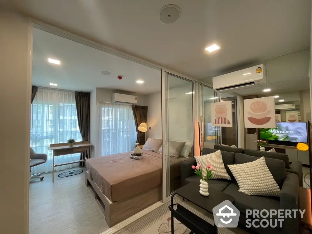 Modern studio apartment with cozy living area and stylish bedroom, featuring large windows and contemporary decor.