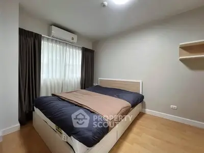 Cozy bedroom with modern design, featuring a comfortable bed and natural light from a large window.