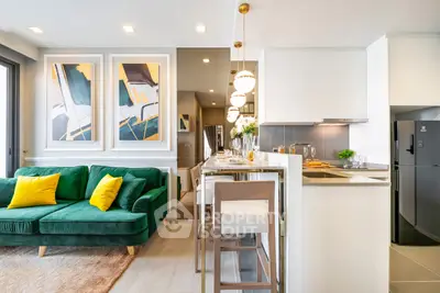 Modern open-plan living room and kitchen with stylish decor and green sofa