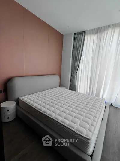 Modern bedroom with stylish bed and floor-to-ceiling windows in a contemporary apartment.