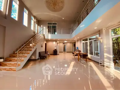 Spacious modern living room with high ceilings and elegant staircase