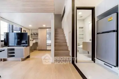 Modern open-plan living area with sleek kitchen and wooden staircase