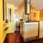 Modern kitchen with vibrant yellow walls and sleek wooden cabinetry