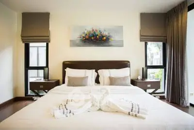 Luxurious bedroom with elegant decor and large windows offering natural light.
