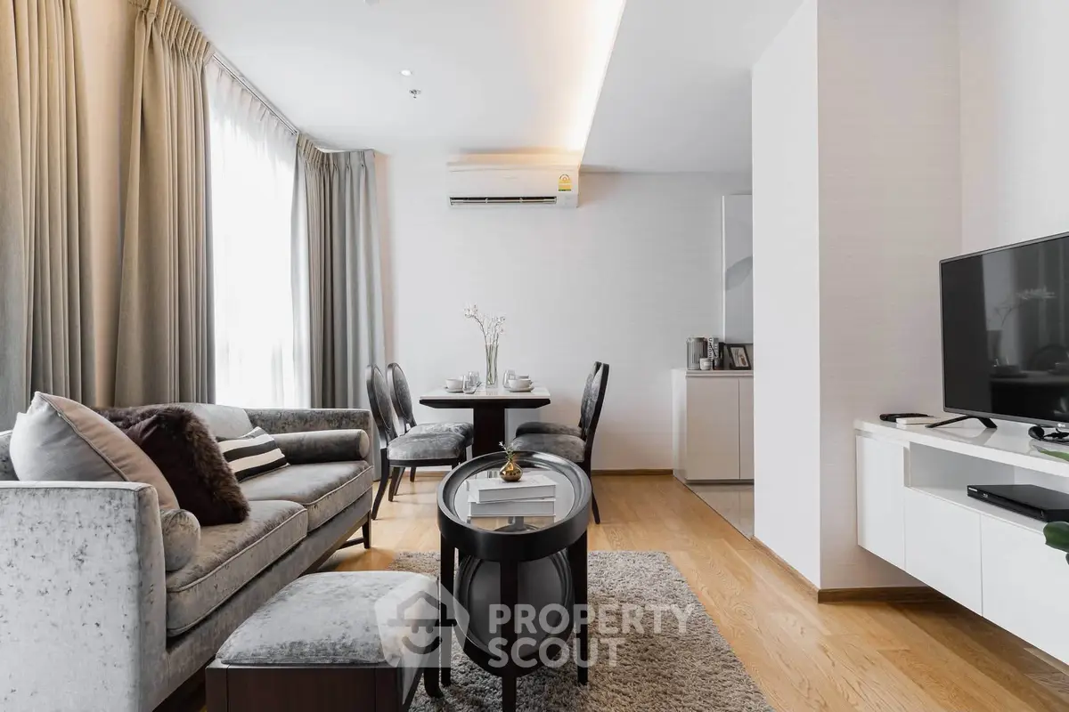 Elegant living room with modern decor, plush sofa, and dining area in a stylish apartment.
