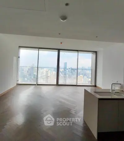 Spacious modern living room with stunning city skyline view through large windows.