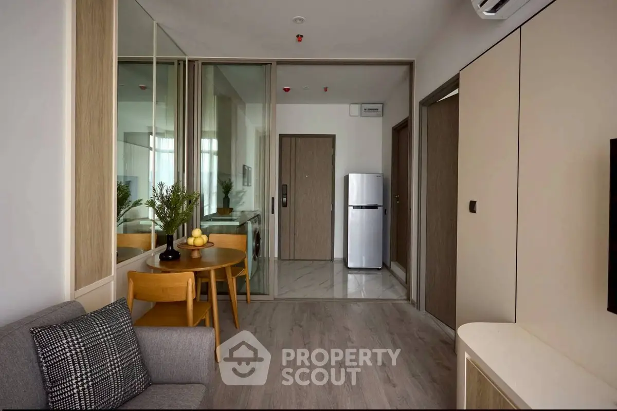 Modern apartment interior with stylish furniture and sleek design, featuring a compact kitchen and cozy living area.