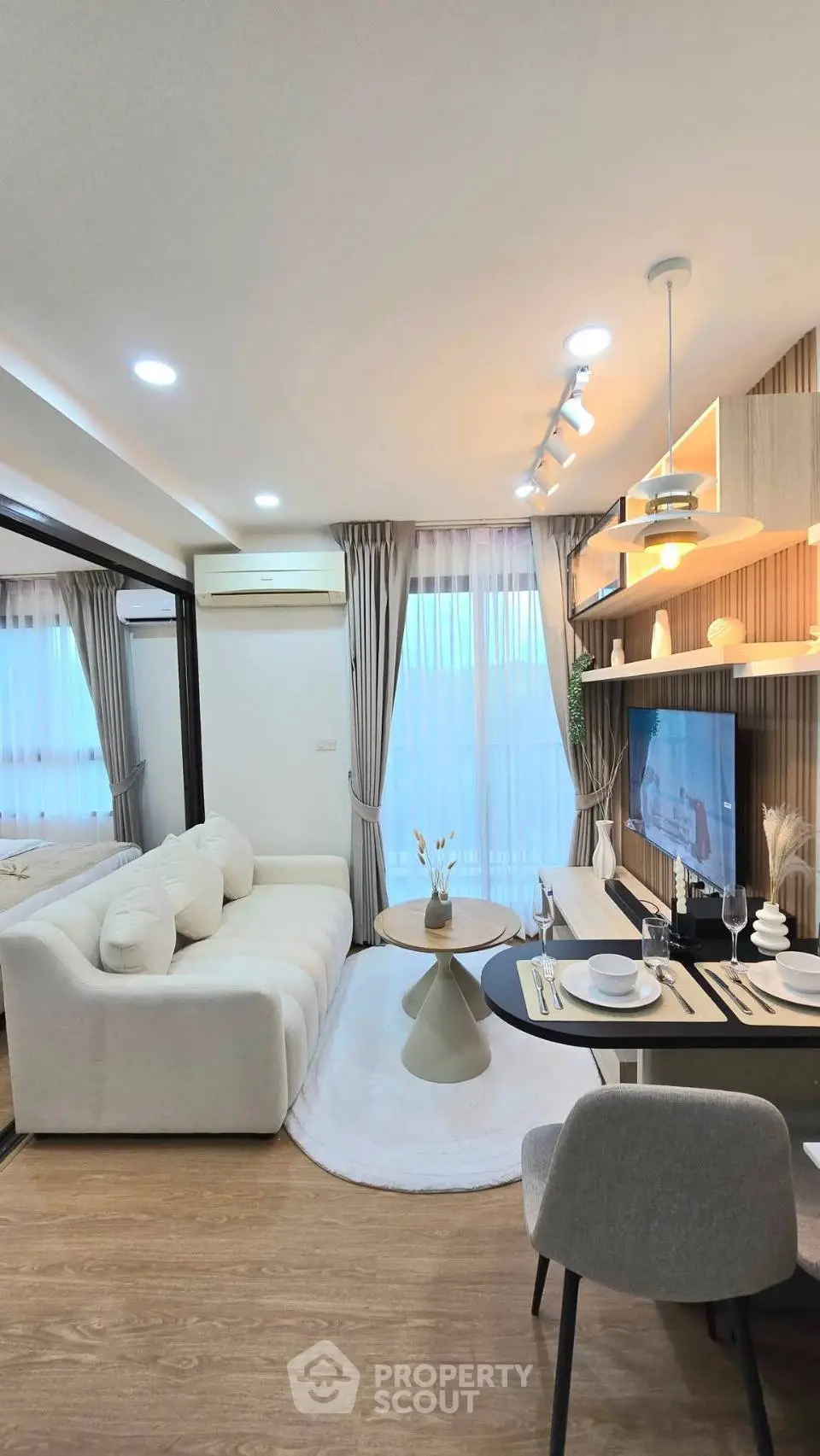 Modern living room with stylish decor, cozy sofa, and elegant dining area, perfect for urban living.