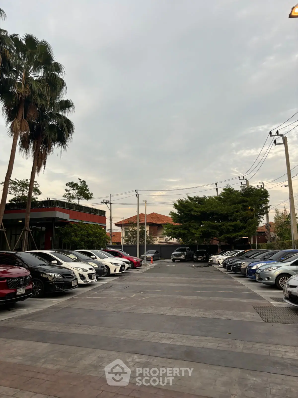 Spacious parking area with multiple cars and lush greenery, ideal for residential or commercial properties.