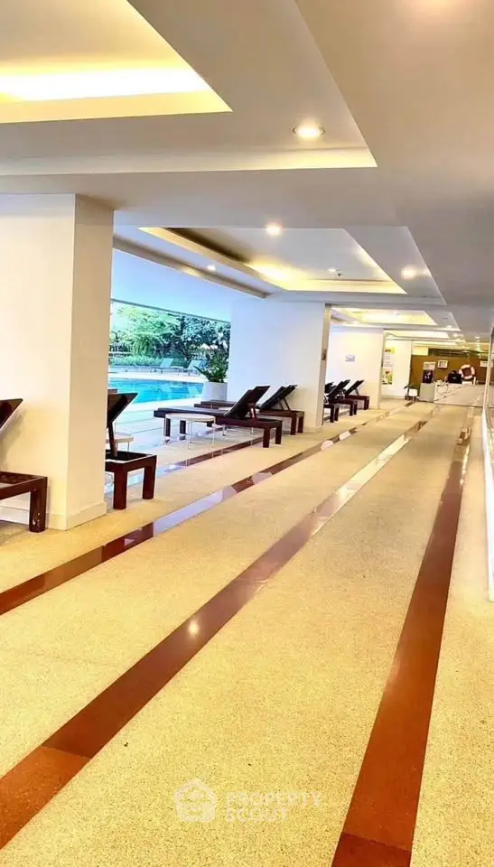 Luxurious indoor pool area with modern lounge chairs and ambient lighting, perfect for relaxation and leisure.