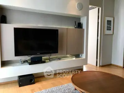 Modern living room with sleek TV setup and wooden flooring