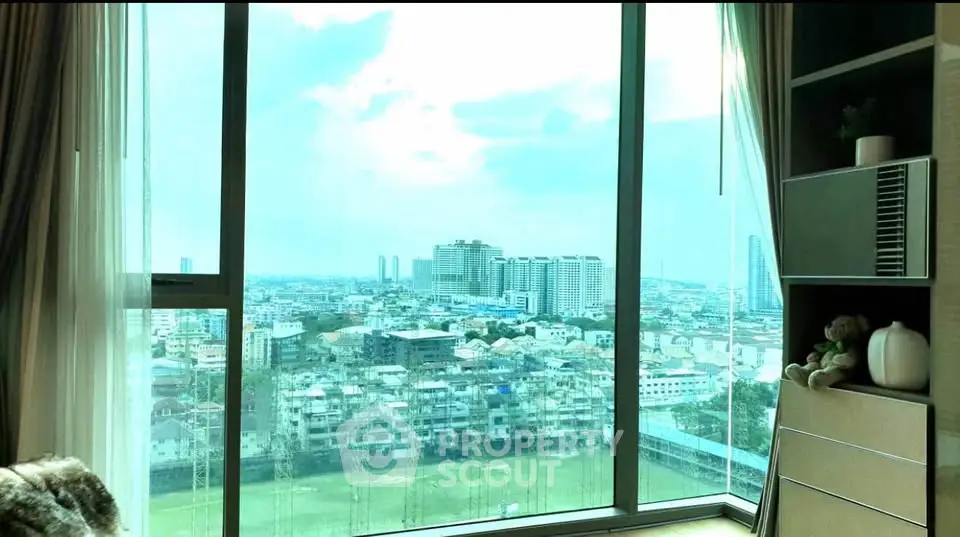 Stunning city view from a modern high-rise apartment with large windows and stylish interior decor.