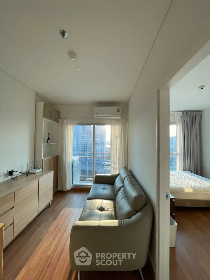 Modern apartment interior with cozy living room and bedroom, featuring wooden flooring and large windows with city view.