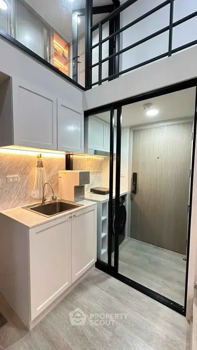 Modern compact kitchen with sleek cabinetry and loft-style design in urban apartment