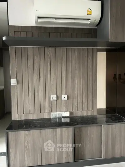 Modern kitchen with sleek wooden cabinetry and air conditioning unit