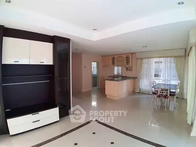 Spacious open-plan living room with modern kitchen and dining area, featuring elegant cabinetry and ample natural light.