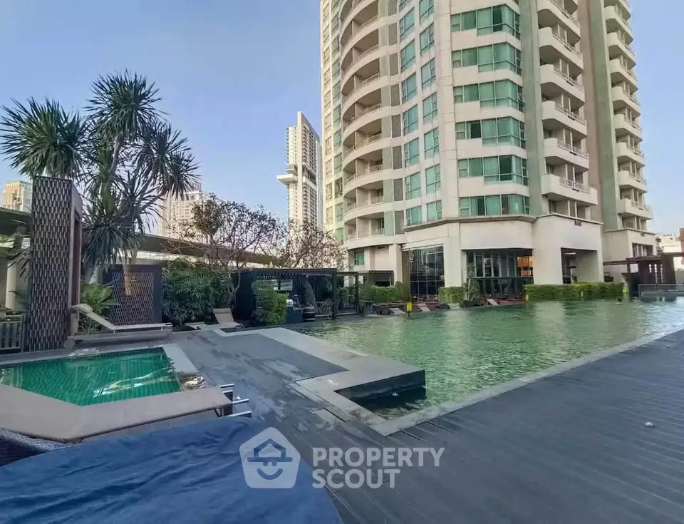 Luxurious high-rise building with stunning pool and lush landscaping in urban setting.