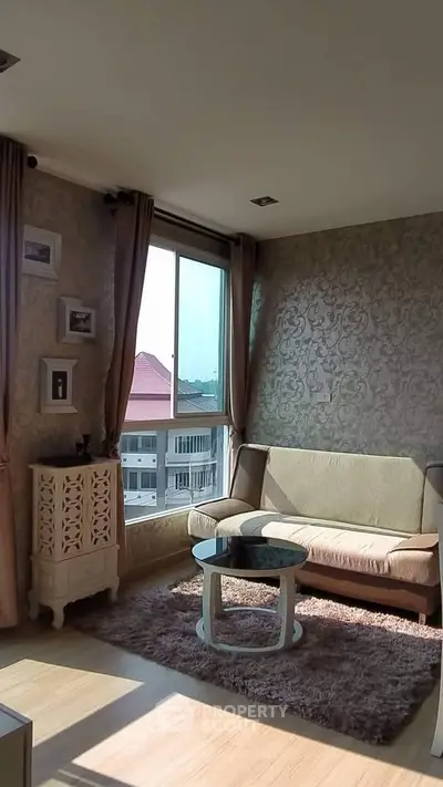 Cozy living room with elegant wallpaper and natural light, featuring a stylish sofa and coffee table.