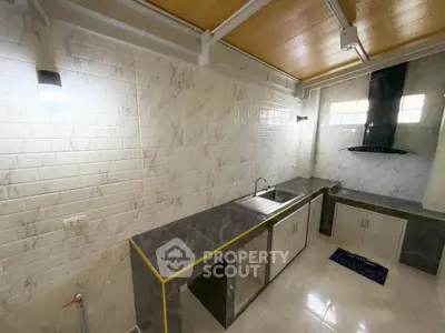 Modern kitchen with sleek countertops and stylish backsplash in a contemporary home.