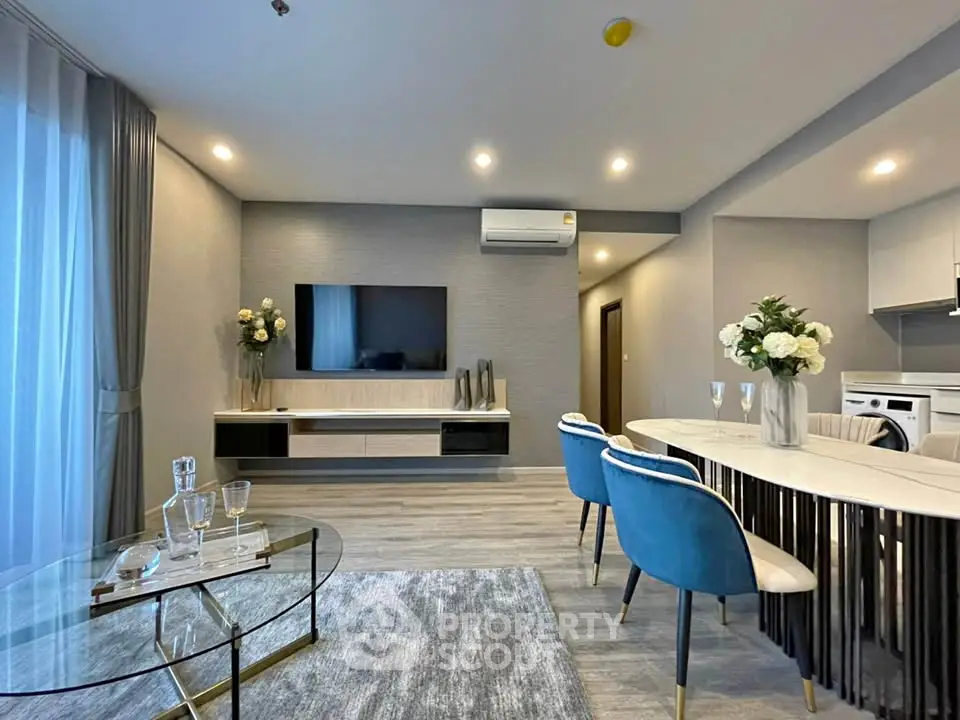 Modern living room with elegant decor, featuring a sleek TV unit, stylish dining area, and plush seating.