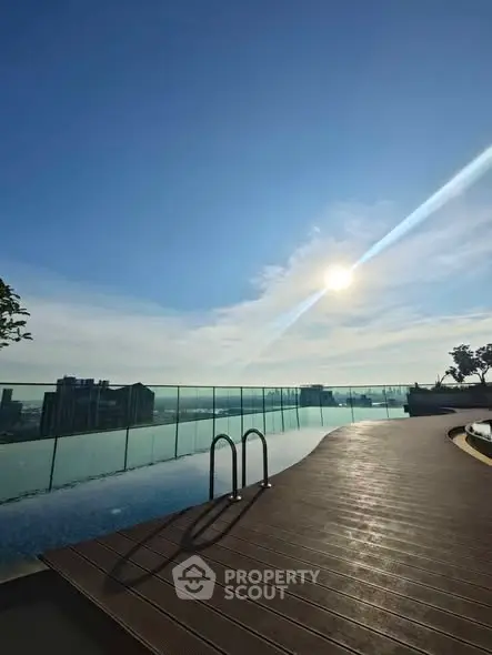 Stunning rooftop pool with panoramic city views under a clear blue sky.