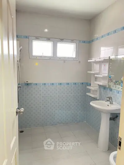 Bright and clean bathroom with modern fixtures and tiled walls.