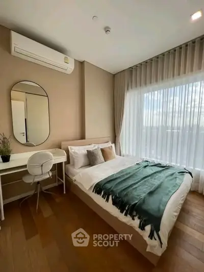 Modern bedroom with large window, stylish decor, and natural light.