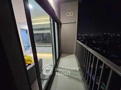 Modern apartment balcony with stunning city night view and glass sliding doors.