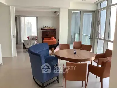 Spacious modern living room with stylish furniture and large windows offering city views.